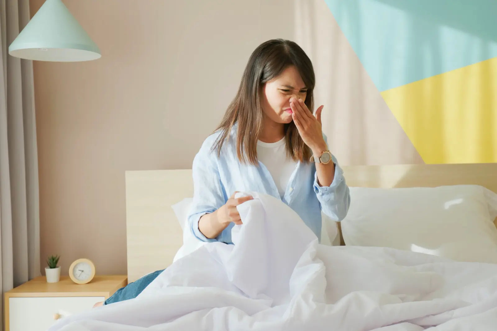 Eine Frau hält sich die Nase zu, um unangenehme Gerüche im Schlafzimmer zu vermeiden