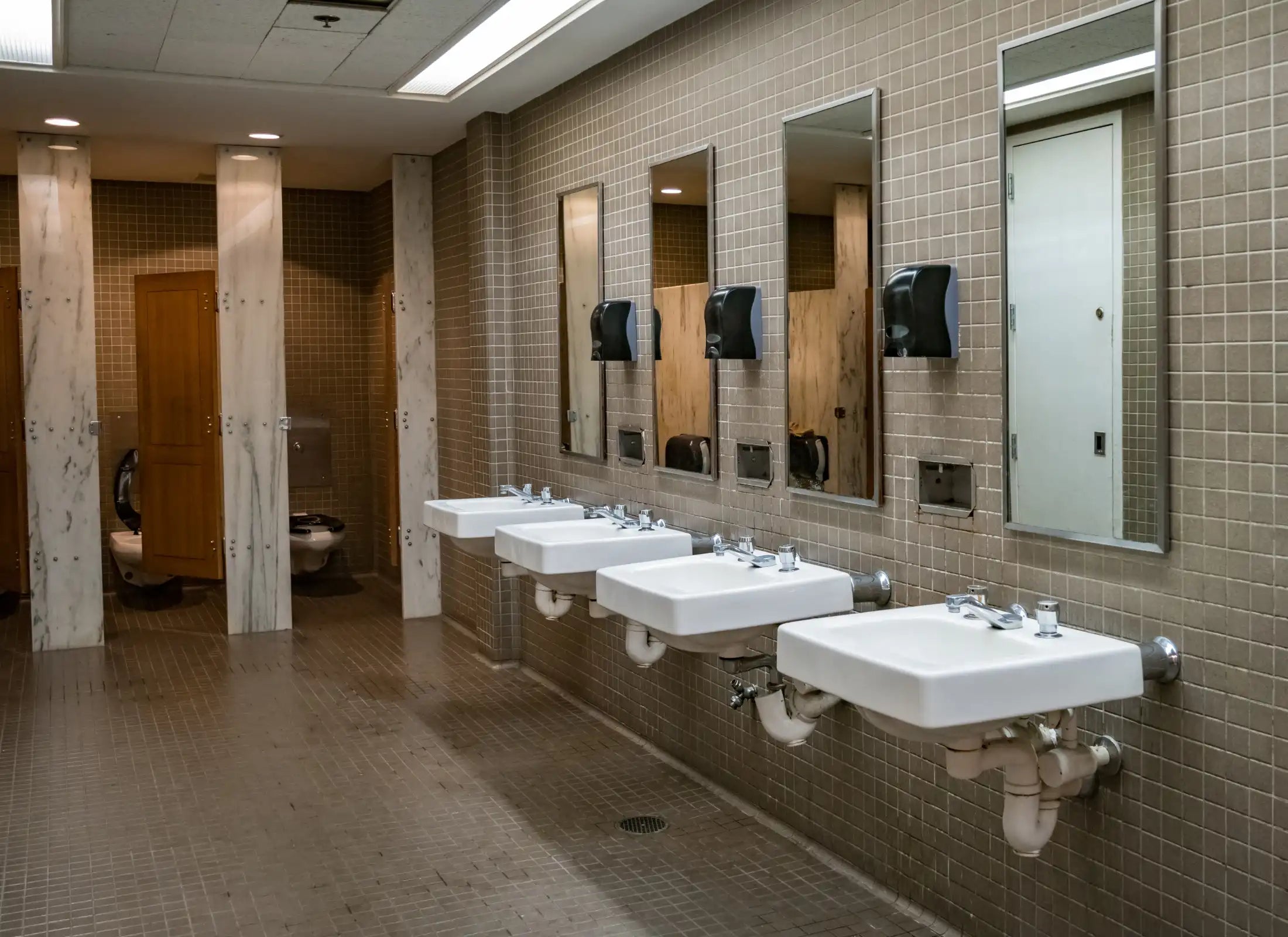 Öffentlicher Waschraum mit Waschbecken und Toilettenkabinen